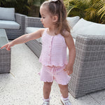 Young girl in a florence lace pink knitted top and shorts standing outdoors on a patio