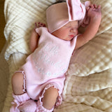 our pretty pink hello world has scalloped edges on short sleeve for arms and delicate knitted frill on legs. At the crotch and down the centre and on shoulder we have added pink resin flower buttons. Matches with our bonnet booties beanie and other pretty pink items. Hello world type in the centre is white surrounded by delicate flowers. The type is in running writing with capital letters at the start - beautiful for baby girl