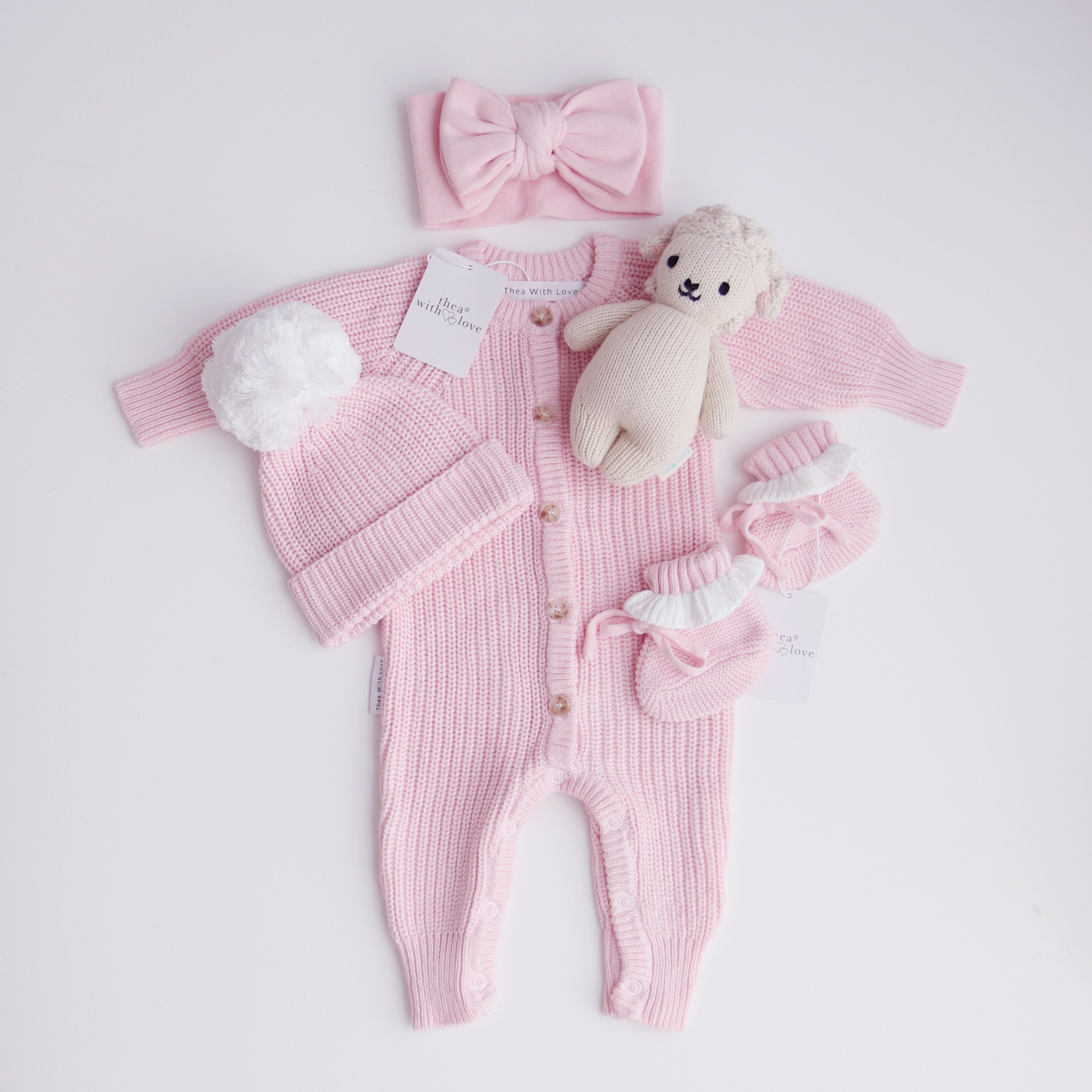 pink knitted booties with warm white frill  at the top of booties. pink bootie lace which can be tied into a bow to secure booties on to baby's foot