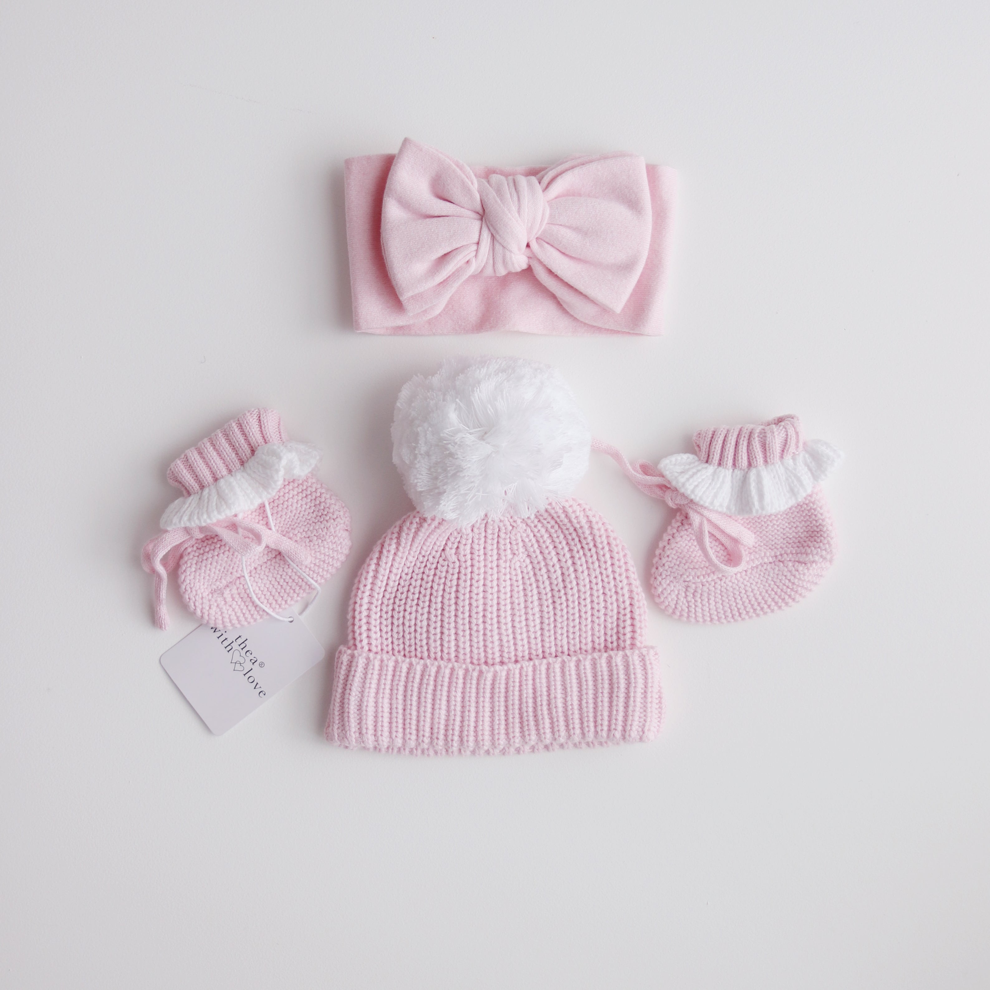 pink knitted booties with warm white frill  at the top of booties. pink bootie lace which can be tied into a bow to secure booties on to baby's foot