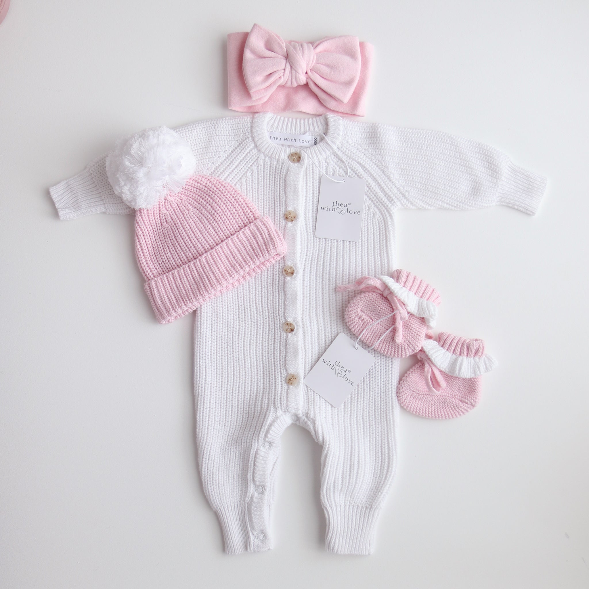 pink knitted booties with warm white frill  at the top of booties. pink bootie lace which can be tied into a bow to secure booties on to baby's foot