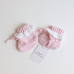 pink knitted booties with warm white frill  at the top of booties. pink bootie lace which can be tied into a bow to secure booties on to baby's foot