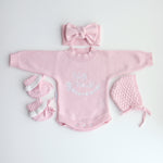 pink knitted booties with warm white frill  at the top of booties. pink bootie lace which can be tied into a bow to secure booties on to baby's foot