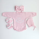 pink knitted booties with warm white frill  at the top of booties. pink bootie lace which can be tied into a bow to secure booties on to baby's foot