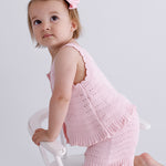 pink knitted short sleeve singlet top. eyelet wave pattern light weight frill on hem, Young girl 3 years old wearing top & shorts