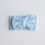 Light blue headband with a bow on a light gray background