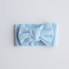 Light blue headband with a bow on a light gray background