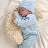 baby wearing chunky knit romper with matching beanie and pom pom booties