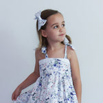 Young girl wearing a floral dress with a white background