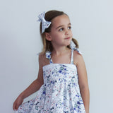 Young girl wearing a floral dress with a white background