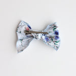 Floral patterned bow with a clip on a light background