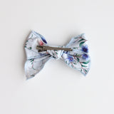 Floral patterned bow with a clip on a light background