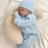baby wearing chunky knit romper with matching beanie and pom pom booties