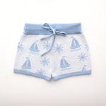 cotton knitted shorts with blue boat pattern on white background. Blue trims and blue elastic waist with drawstring. Waist band is 4 cm high and the leg trim is 1.5 cm high