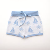 cotton knitted shorts with blue boat pattern on white background. Blue trims and blue elastic waist with drawstring. Waist band is 4 cm high and the leg trim is 1.5 cm high