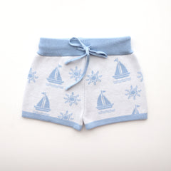 cotton knitted shorts with blue boat pattern on white background. Blue trims and blue elastic waist with drawstring. Waist band is 4 cm high and the leg trim is 1.5 cm high