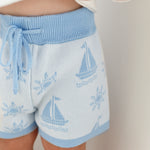cotton knitted shorts with blue boat pattern on white background. Blue trims and blue elastic waist with drawstring. Waist band is 4 cm high and the leg trim is 1.5 cm high