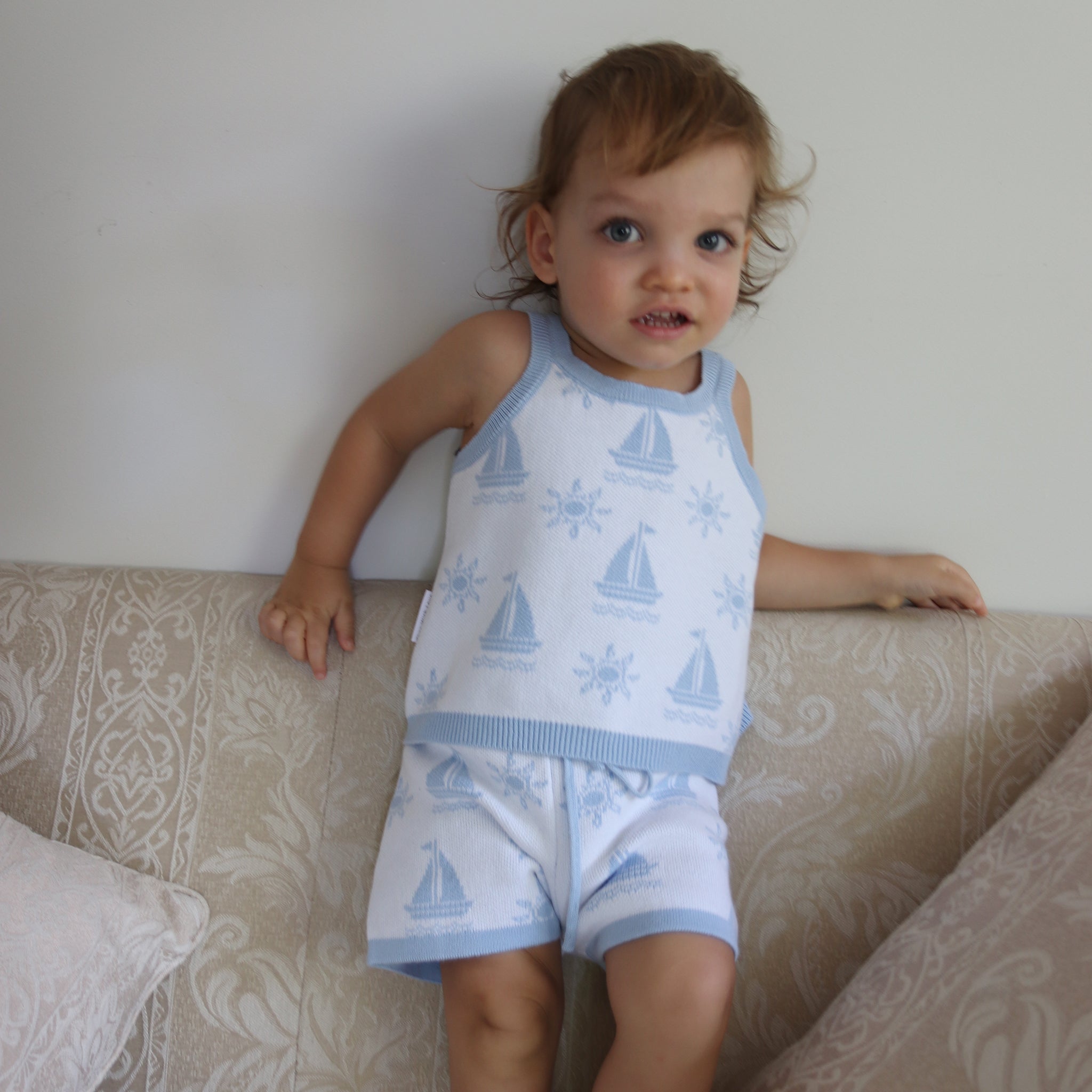 cotton knitted shorts with blue boat pattern on white background. Blue trims and blue elastic waist with drawstring. Waist band is 4 cm high and the leg trim is 1.5 cm high