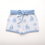 cotton knitted shorts with blue boat pattern on white background. Blue trims and blue elastic waist with drawstring. Waist band is 4 cm high and the leg trim is 1.5 cm high