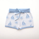 cotton knitted shorts with blue boat pattern on white background. Blue trims and blue elastic waist with drawstring. Waist band is 4 cm high and the leg trim is 1.5 cm high