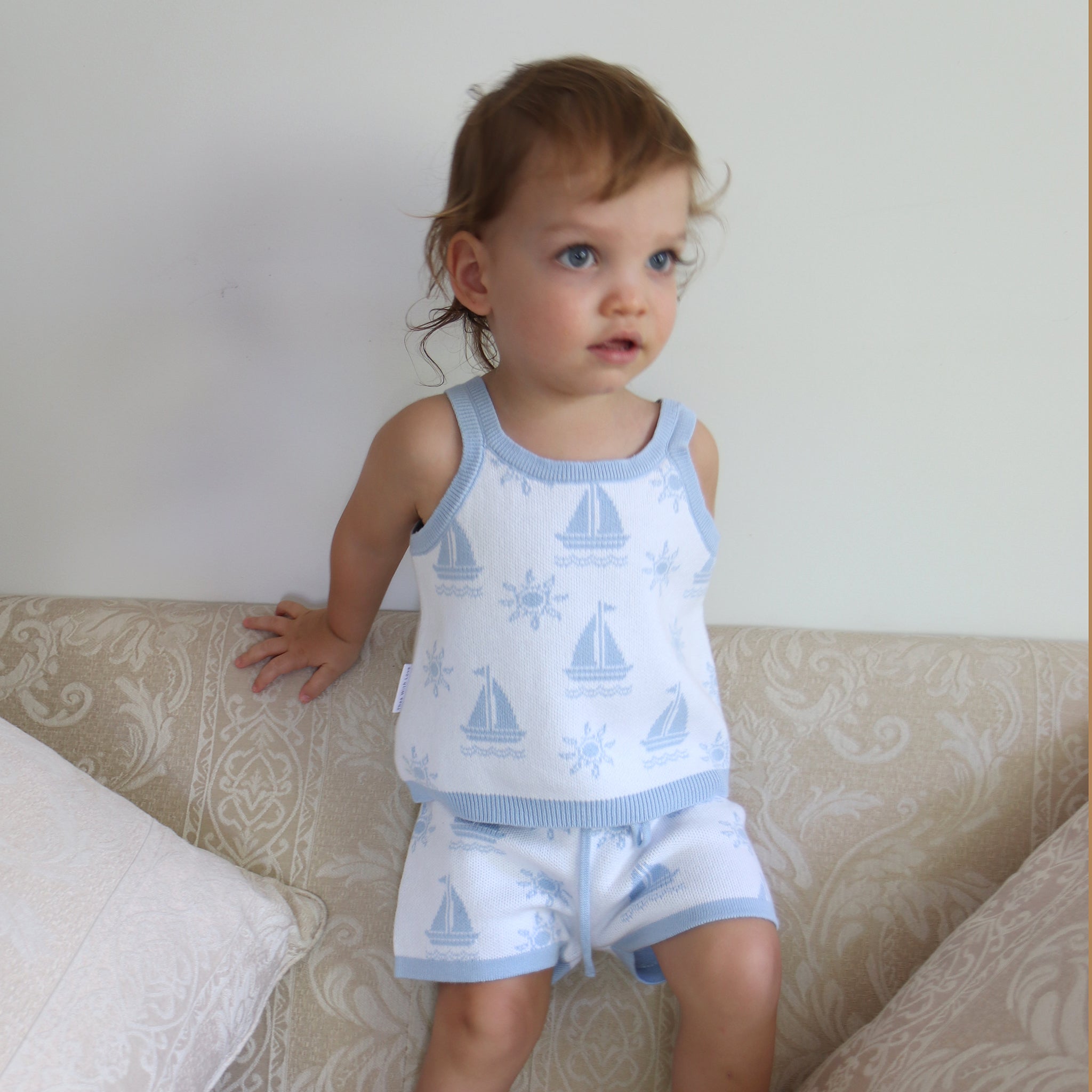 cotton knitted shorts with blue boat pattern on white background. Blue trims and blue elastic waist with drawstring. Waist band is 4 cm high and the leg trim is 1.5 cm high