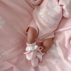 baby girl wearing pin frilly booties and romper