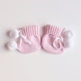 cute pom pom booties - booties are pink with warm white pom pom and warm white lace tied in bow to secure booties