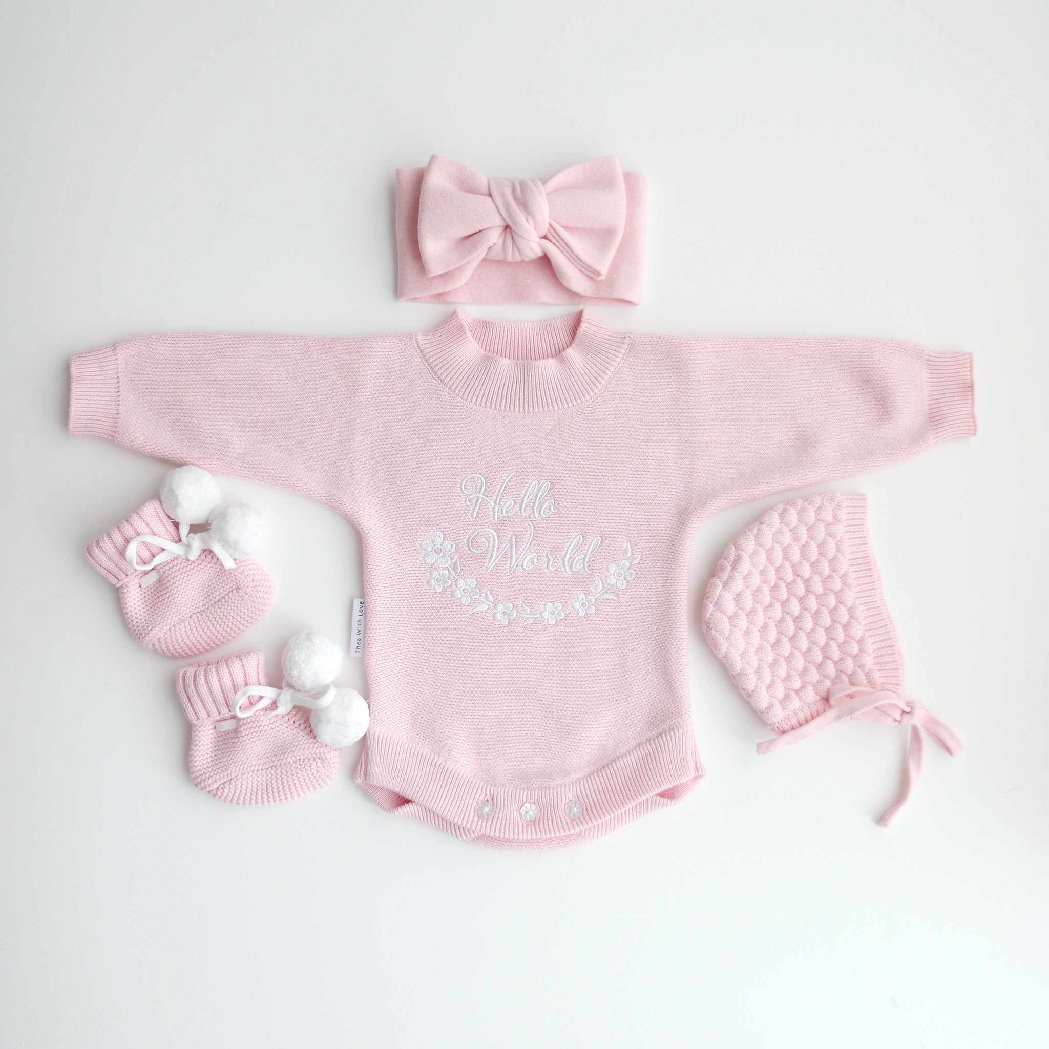 cute pom pom booties - booties are pink with warm white pom pom and warm white lace tied in bow to secure booties