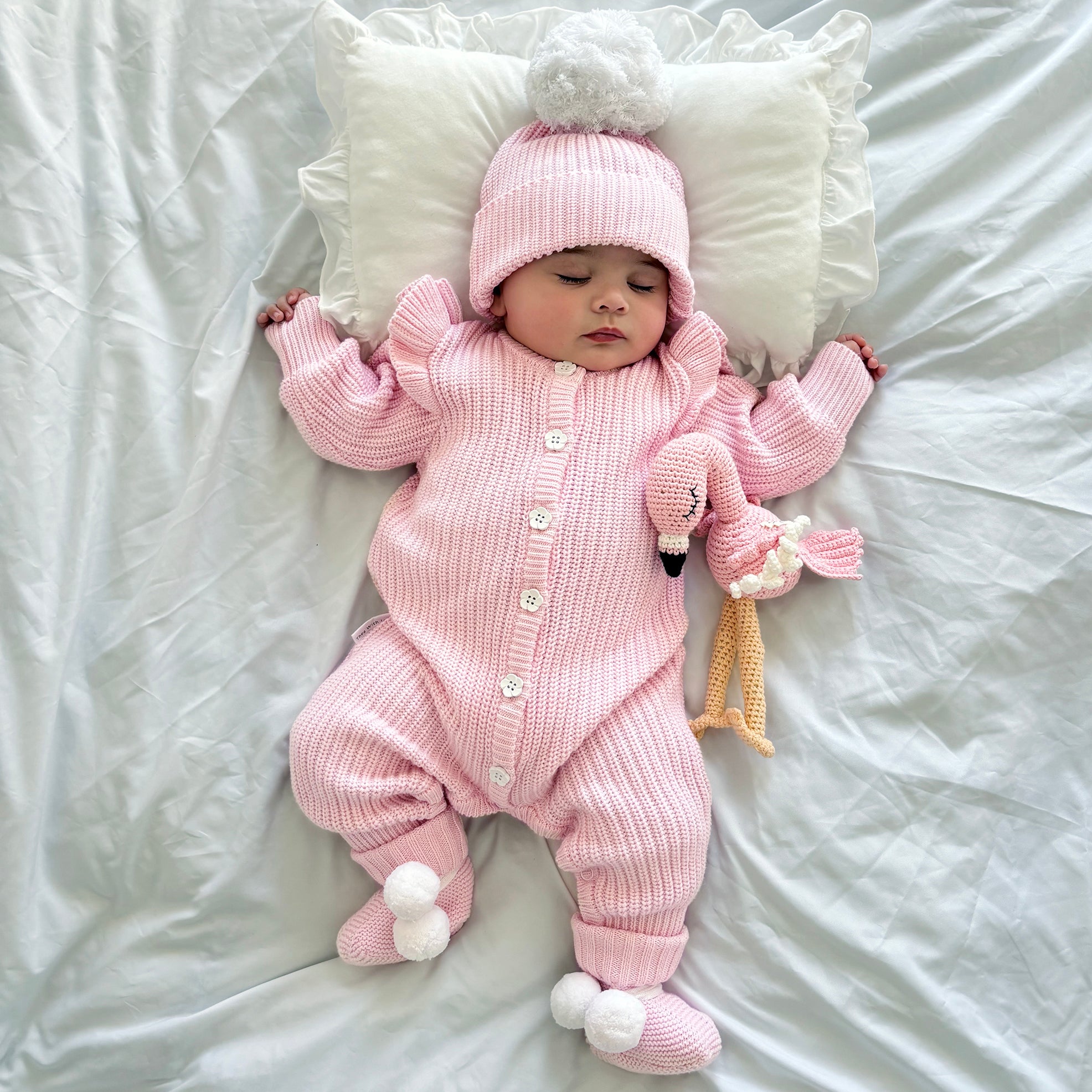 cute pom pom booties - booties are pink with warm white pom pom and warm white lace tied in bow to secure booties