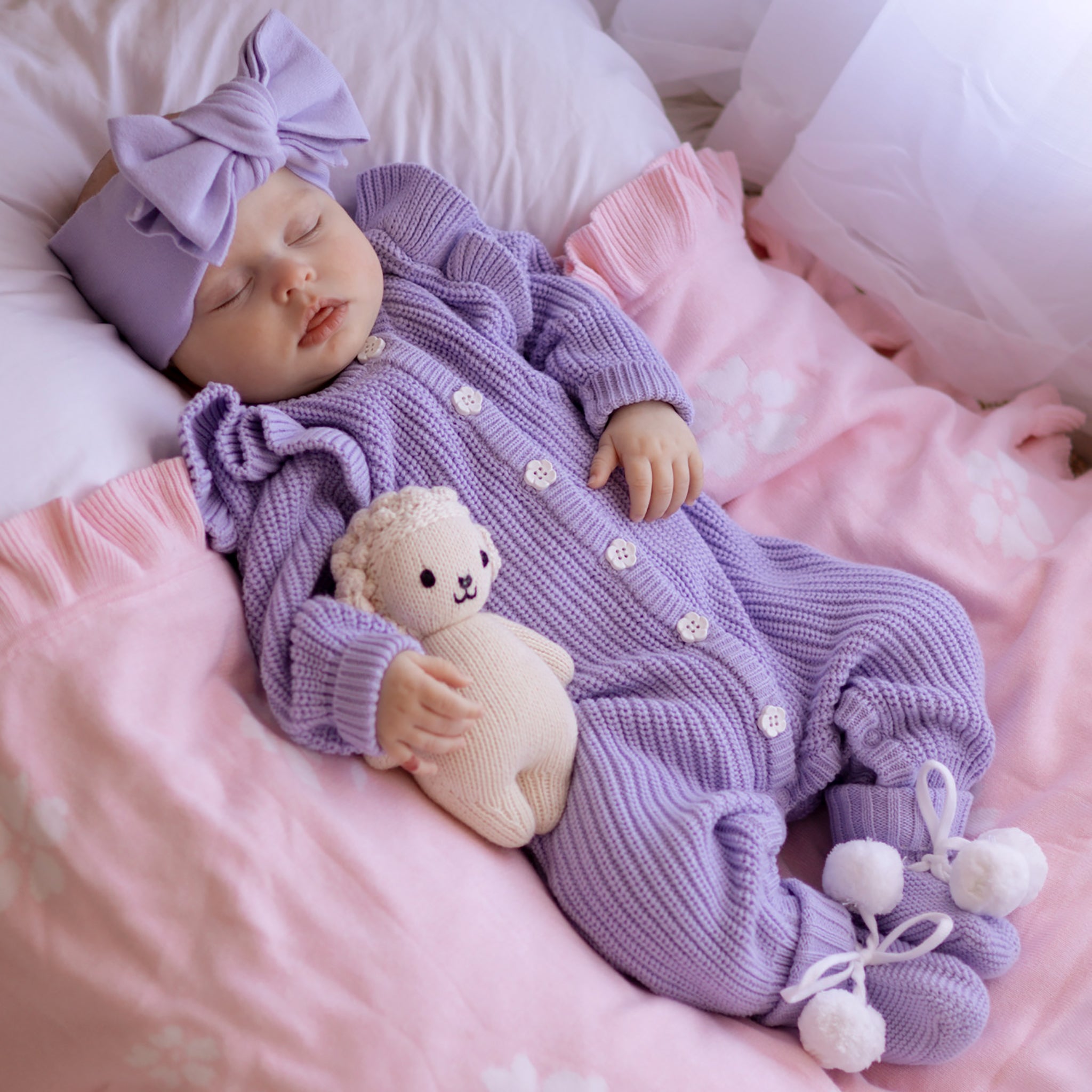 Frilly Lavender Romper baby wearing the outfit with a bow