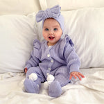 BABY WEARING BOW BOOTIES AND ROMPER