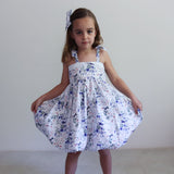 Young girl wearing a floral dress against a plain background