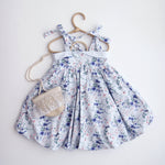 Floral dress on a hanger against a white background