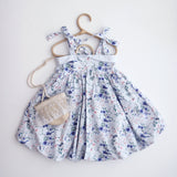 Floral dress on a hanger against a white background