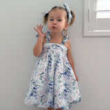 Young girl wearing a floral dress with a plain background

Details