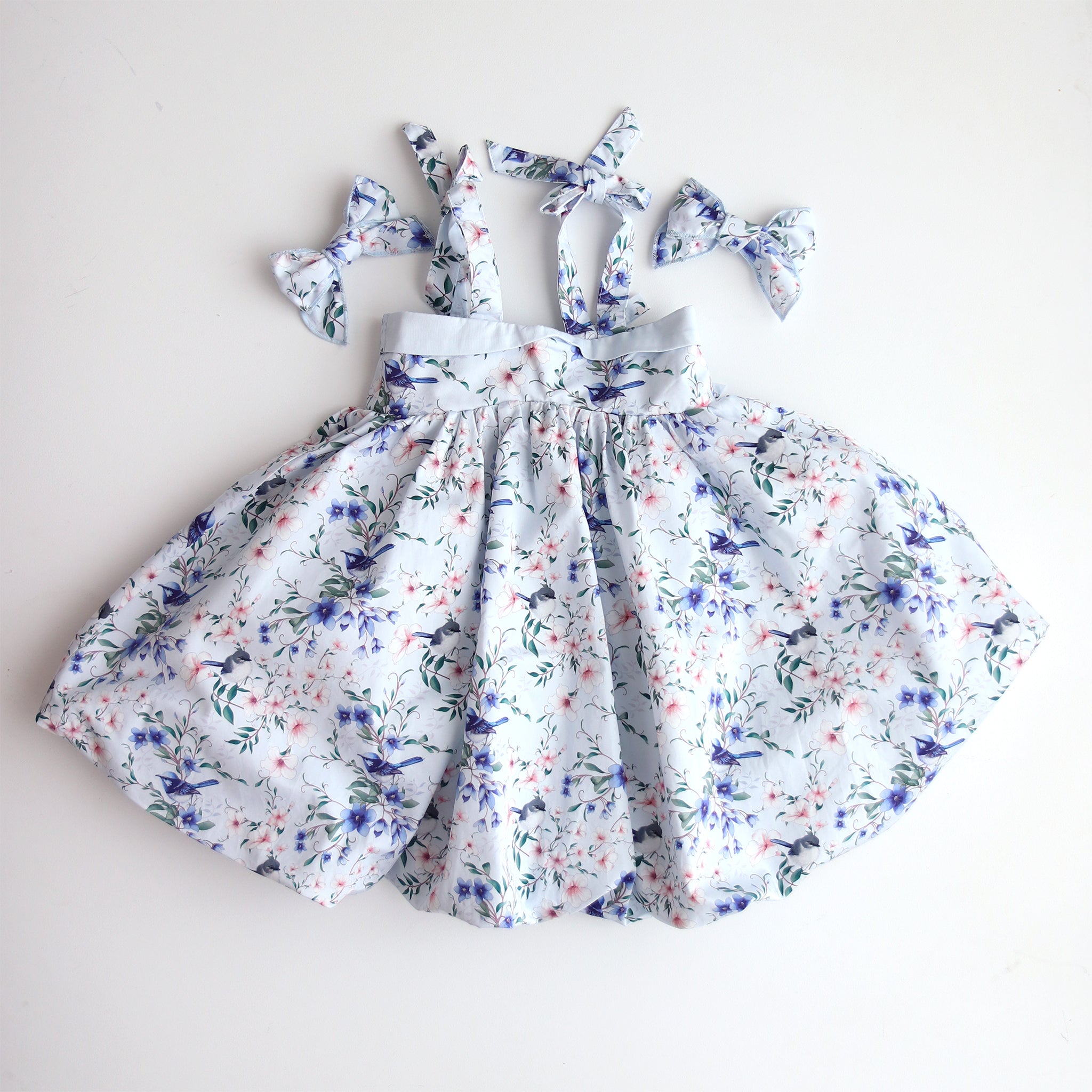 Floral dress with matching headbands on a light gray backgroun