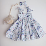 Floral dress with matching headbands and a small bag on a light background