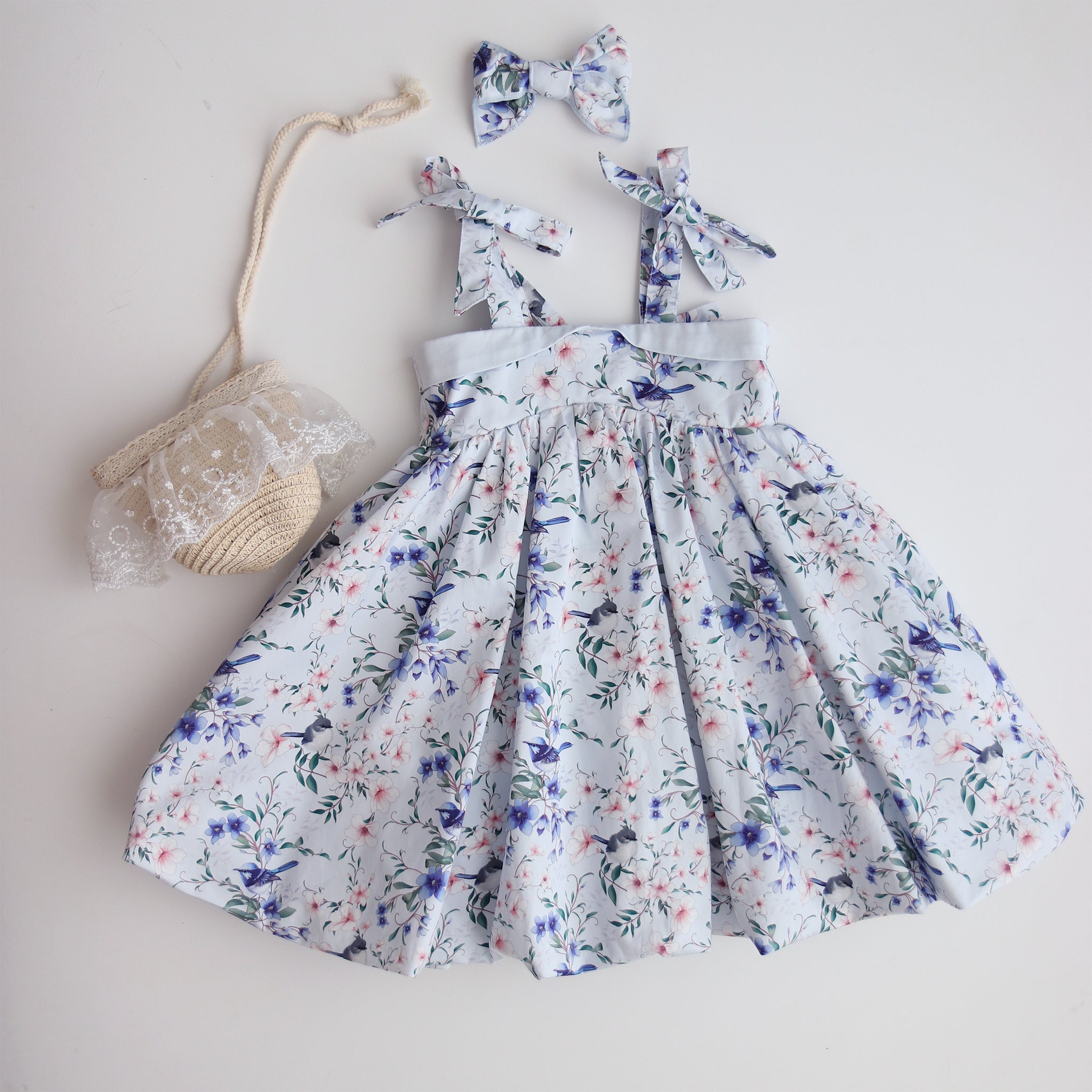 Floral dress with matching headbands and a small bag on a light background