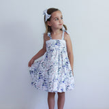 Young girl wearing a floral dress against a plain background