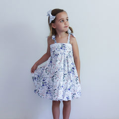 Young girl wearing a floral dress against a plain background