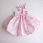 Pink gingham dress on a white background