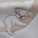 Flatlay of the Hello World Koala romper showing the embroidery imperfection — the koala’s face appears untidy with a slightly larger nose.