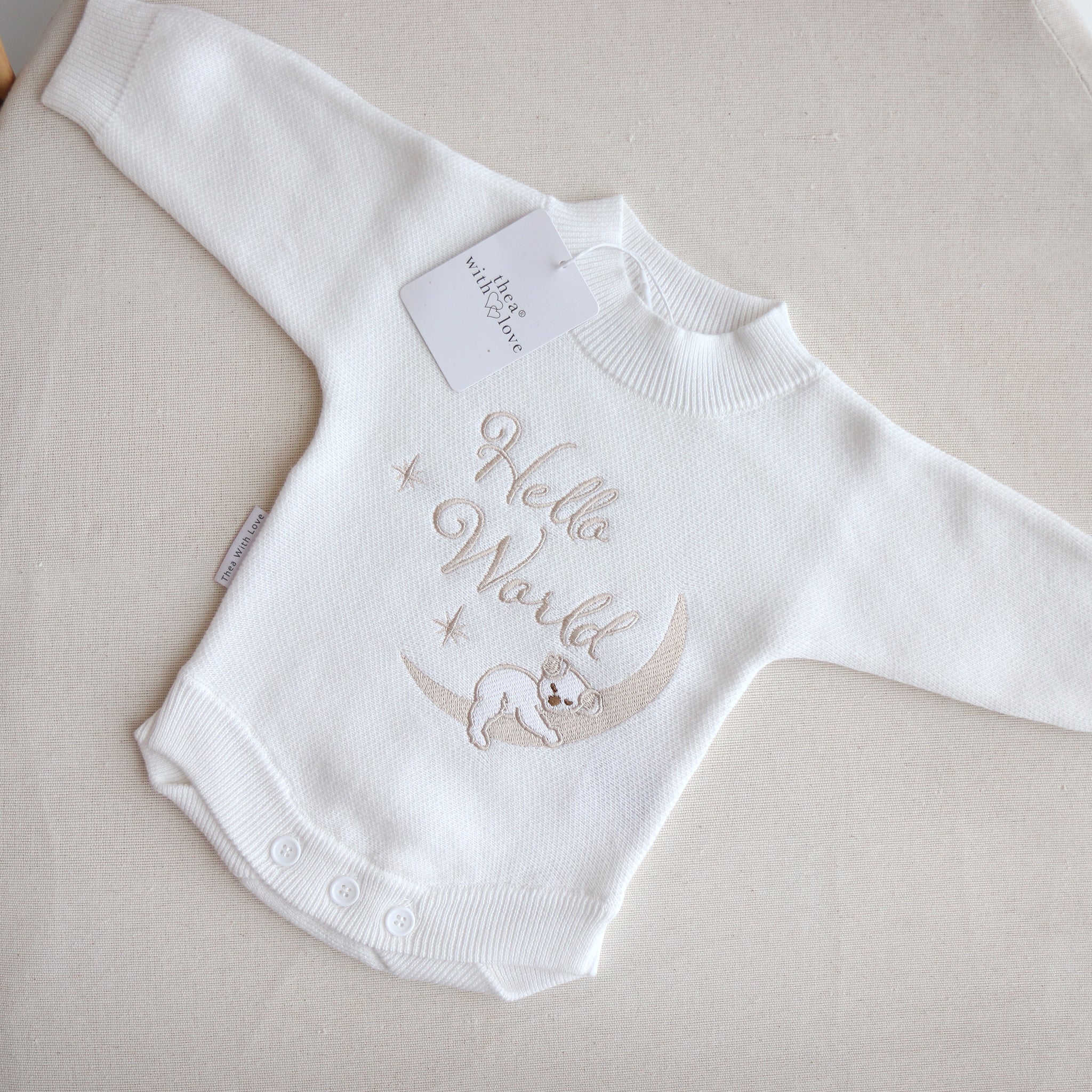 Flatlay of the Hello World Koala romper showing the embroidery imperfection — the koala’s face appears untidy with a slightly larger nose.