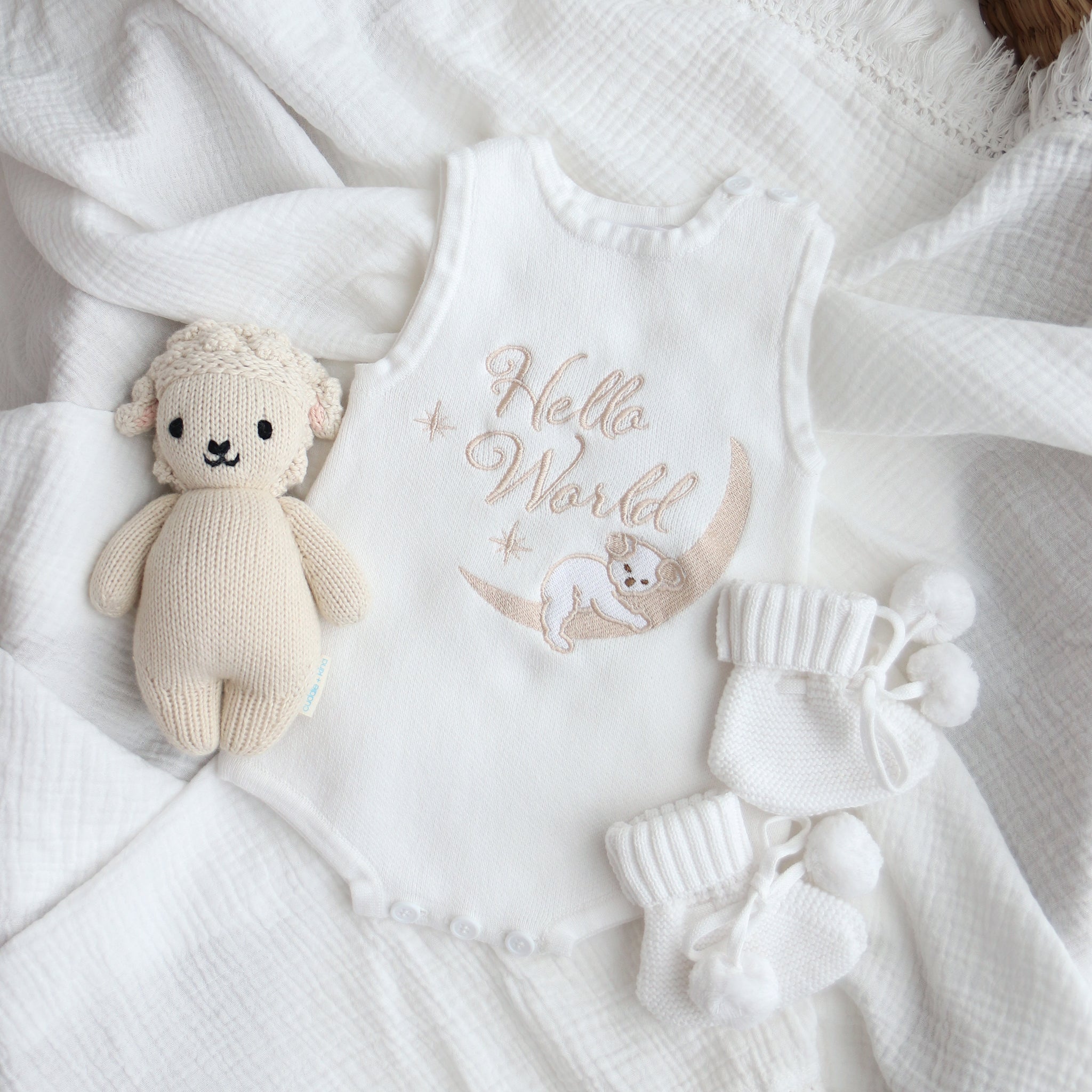 Our koala hello world summer features a baby koala sleeping on eclipse shape  moon. 2 stars are also added. The embroidery is running writing. The embroidery yarn is glossy so the hello world shines in the sunlight. Romper is white knitted fabric. short sleeves and legs for summer. 