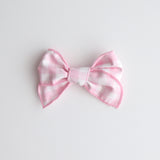 Pink and white bow on a light gray background