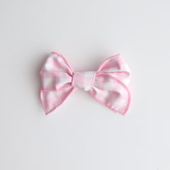 Pink and white bow on a light gray background