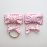 Set of pink and white checkered hair accessories on a light gray background