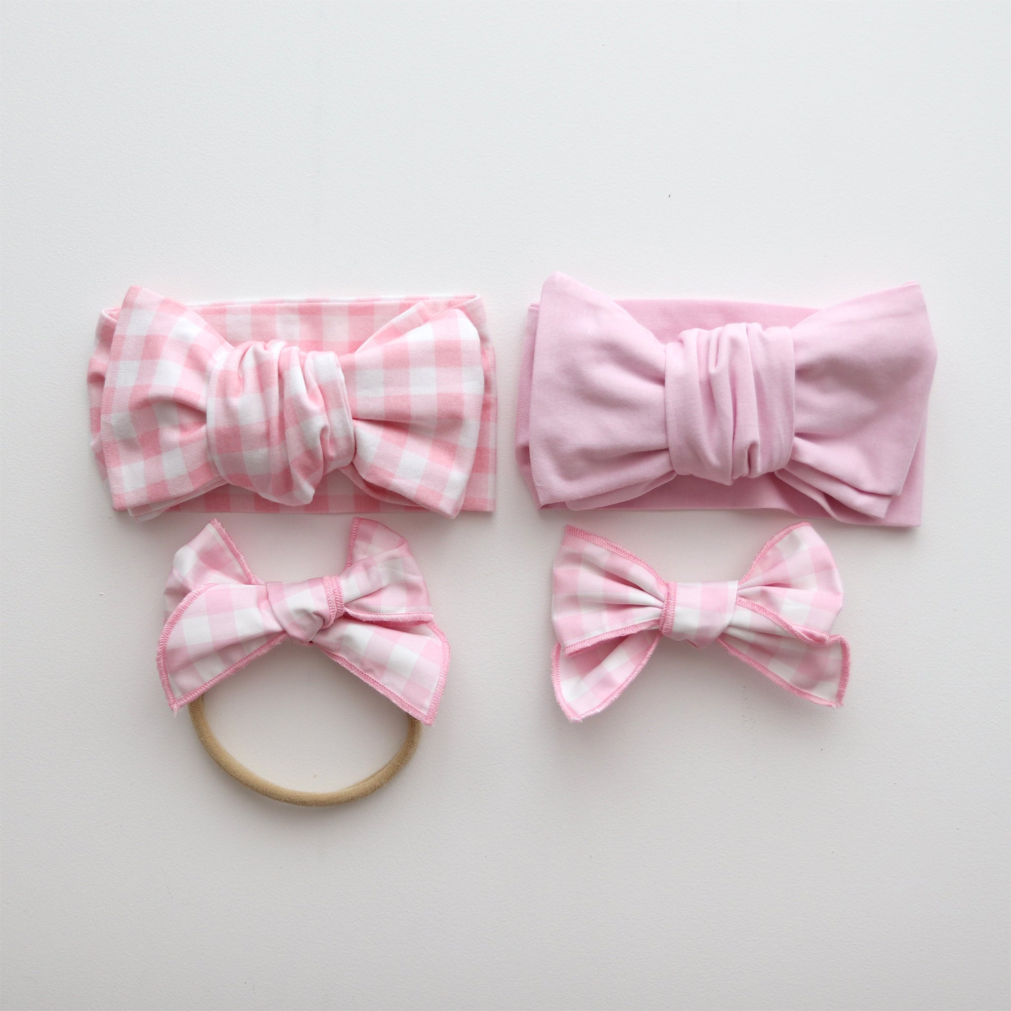 Set of pink and white checkered hair accessories on a light gray background