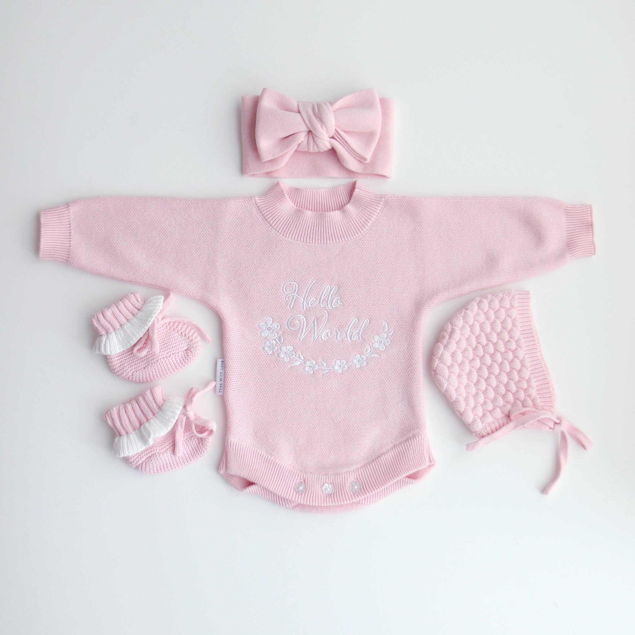 pink knitted booties with warm white frill  at the top of booties. pink bootie lace which can be tied into a bow to secure booties on to baby's foot