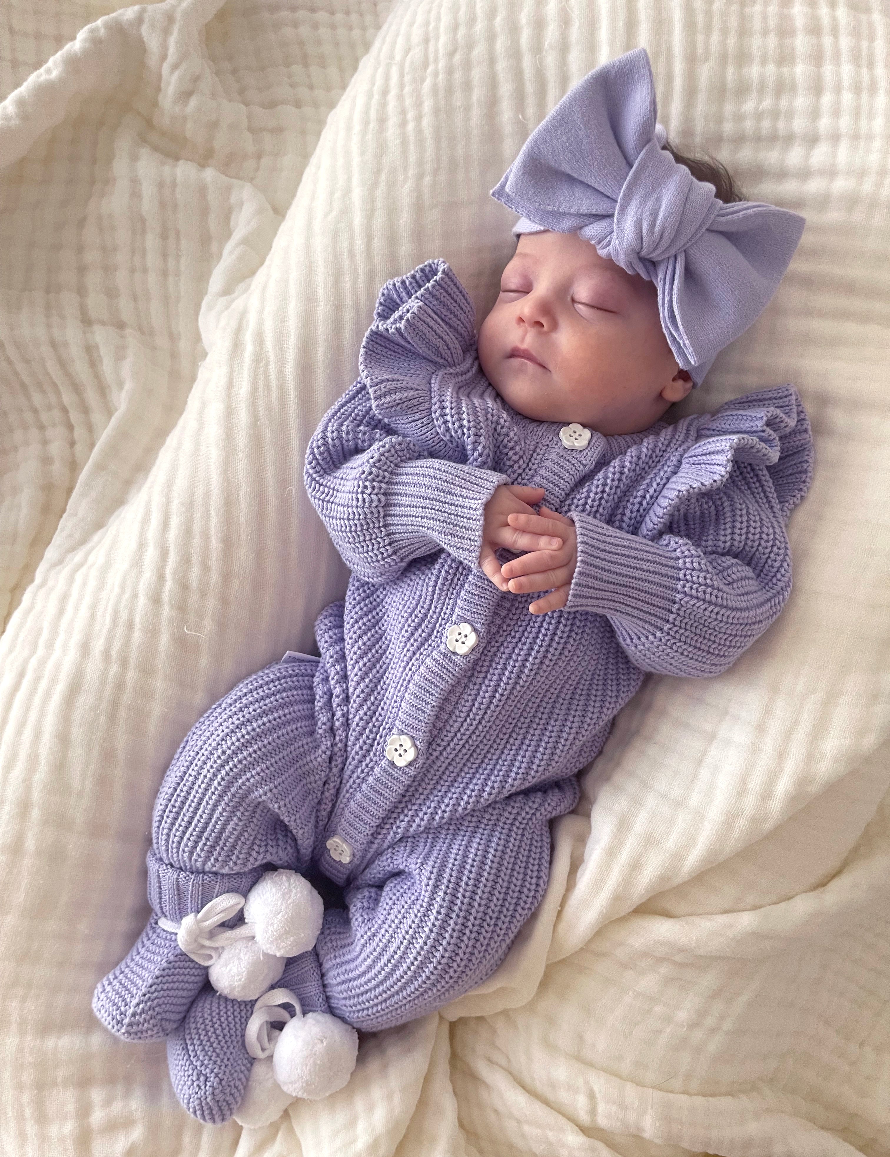 Frilly Lavender Romper baby wearing the outfit with a bow